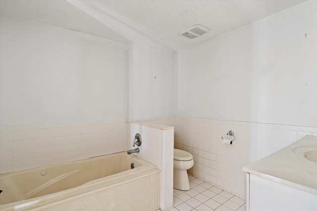 bathroom featuring tile patterned flooring, vanity, a bath, toilet, and tile walls