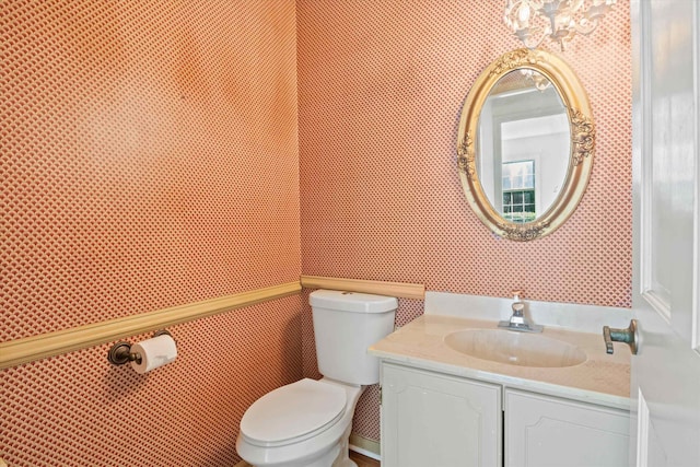 bathroom with vanity, a chandelier, and toilet