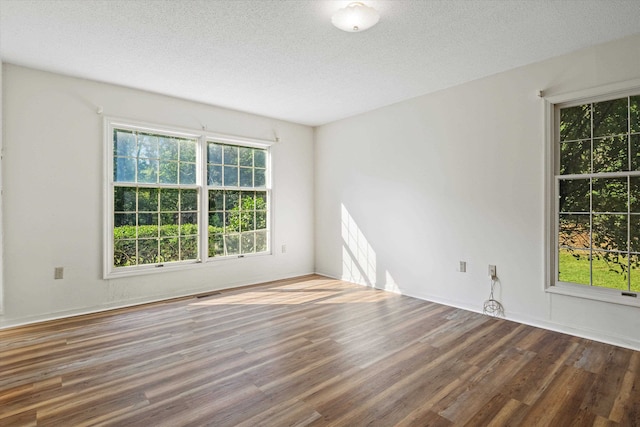 unfurnished room with hardwood / wood-style floors and a textured ceiling