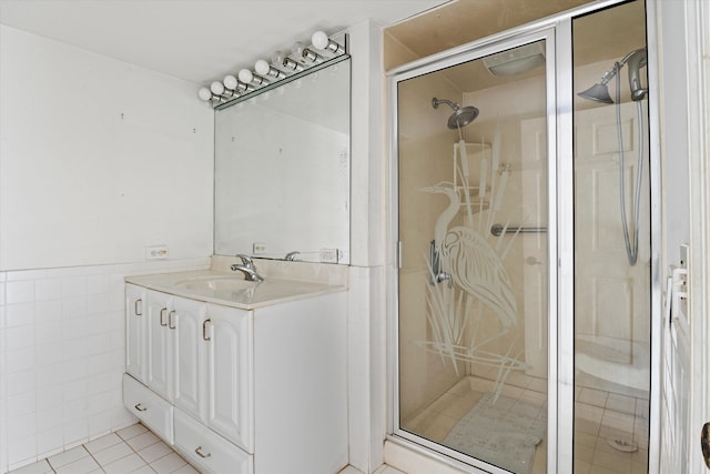 bathroom featuring tile walls, vanity, tile patterned flooring, and a shower with shower door