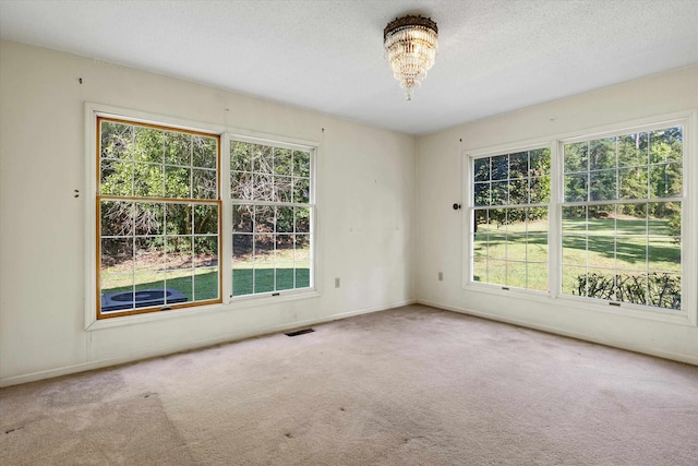 carpeted empty room with a textured ceiling