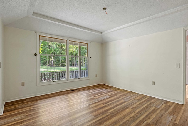 unfurnished room with a textured ceiling and hardwood / wood-style flooring