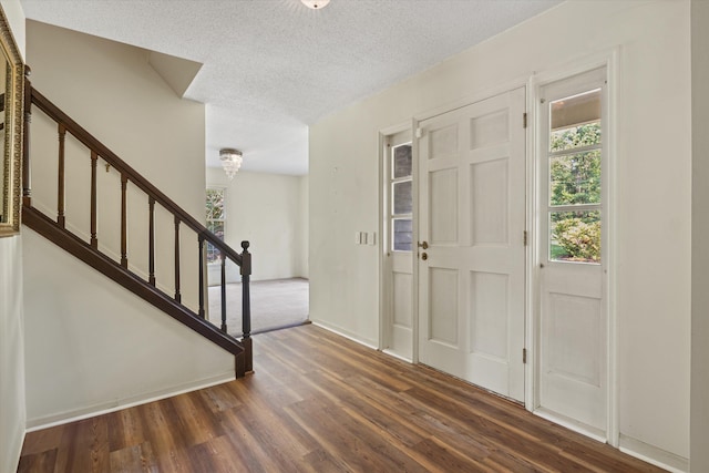 entrance foyer with dark hardwood / wood-style flooring and a textured ceiling