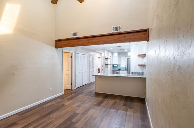 kitchen with dark hardwood / wood-style flooring, kitchen peninsula, hanging light fixtures, tasteful backsplash, and ceiling fan