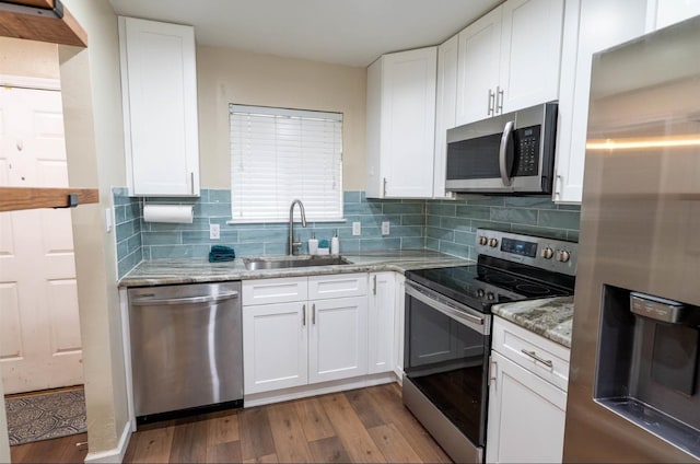 kitchen with stainless steel appliances, light hardwood / wood-style floors, white cabinetry, sink, and light stone counters