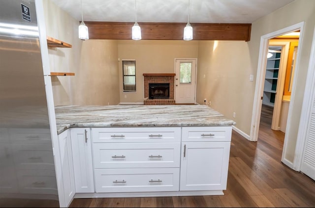 kitchen with hanging light fixtures, dark hardwood / wood-style flooring, white cabinetry, and light stone counters