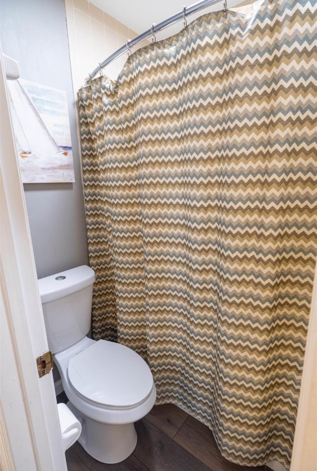 bathroom with curtained shower and toilet