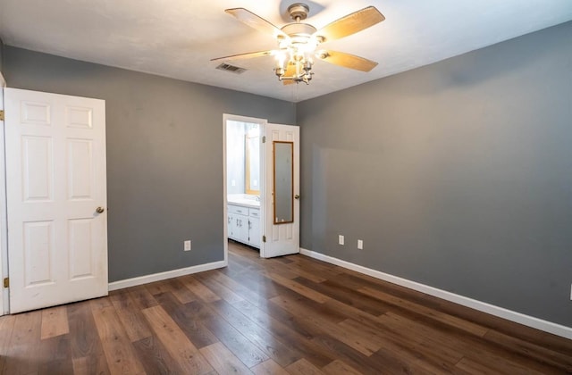 unfurnished bedroom featuring dark hardwood / wood-style flooring, ceiling fan, and ensuite bath