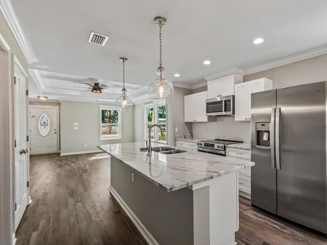 kitchen with appliances with stainless steel finishes, sink, white cabinets, an island with sink, and light stone countertops