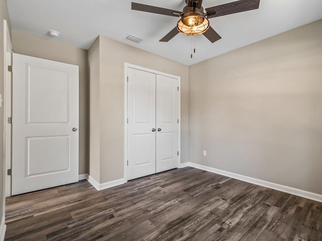 unfurnished bedroom with a closet, dark hardwood / wood-style floors, and ceiling fan