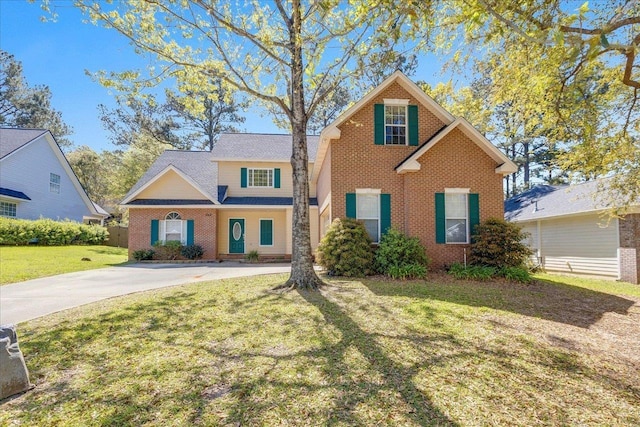 traditional-style home with brick siding, driveway, and a front lawn