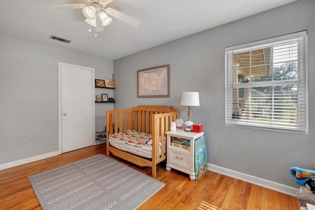 bedroom featuring multiple windows, ceiling fan, and light wood-type flooring