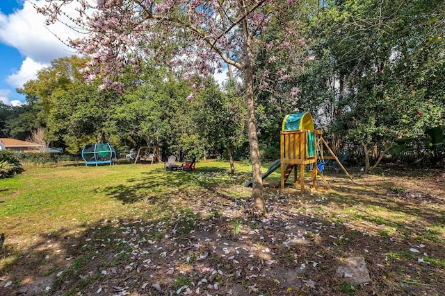 view of playground featuring a trampoline and a yard