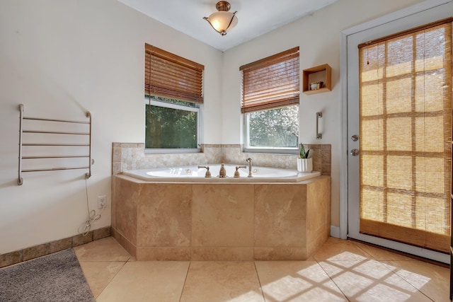 bathroom with tiled tub and tile patterned floors