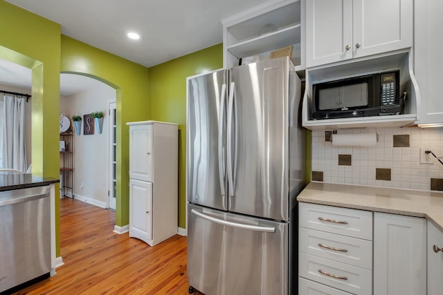 kitchen featuring tasteful backsplash, light hardwood / wood-style flooring, stainless steel appliances, and white cabinets