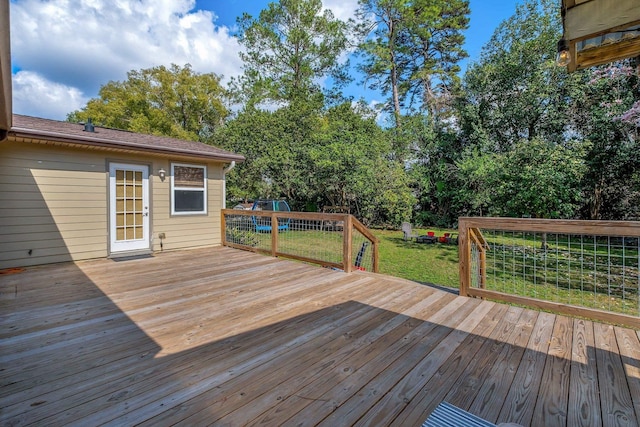 wooden deck featuring a lawn