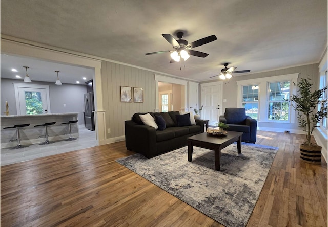 living room featuring hardwood / wood-style flooring, crown molding, and a wealth of natural light