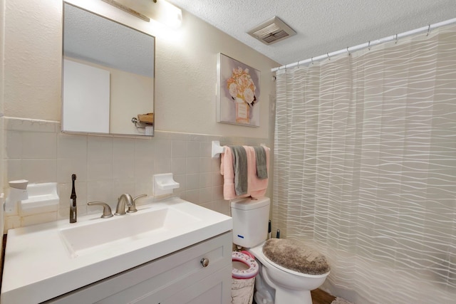 bathroom with toilet, tile walls, a textured ceiling, vanity, and a shower with shower curtain