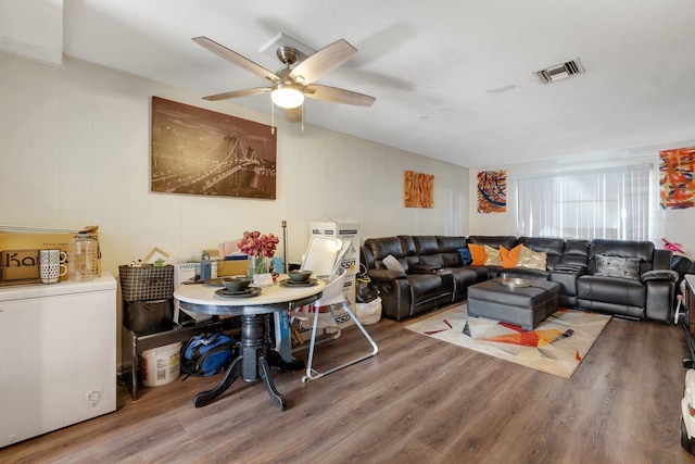 living room featuring a textured ceiling, hardwood / wood-style floors, and ceiling fan