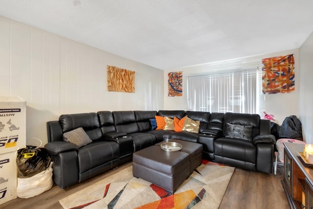 living room featuring light wood-type flooring and a textured ceiling