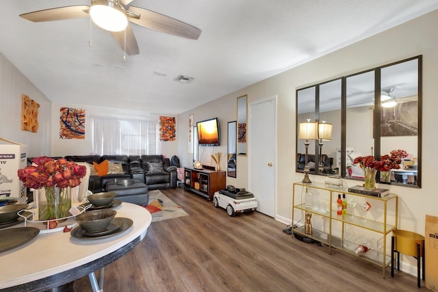 living room featuring hardwood / wood-style flooring, ceiling fan, and a textured ceiling