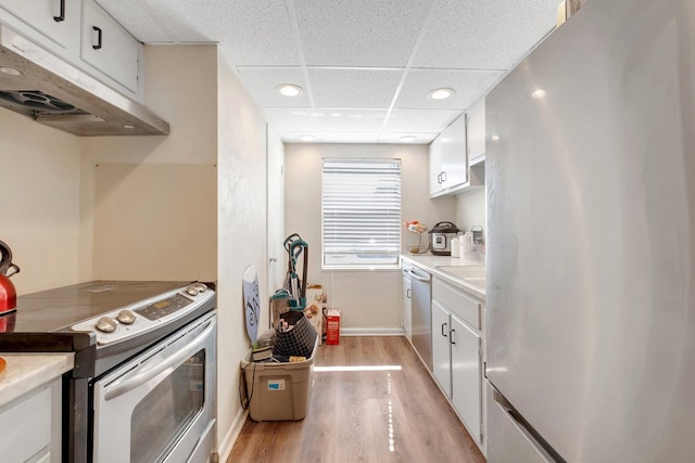 kitchen featuring a paneled ceiling, white cabinetry, light hardwood / wood-style floors, and stainless steel appliances