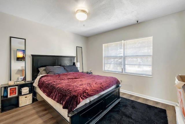 bedroom with wood-type flooring and a textured ceiling