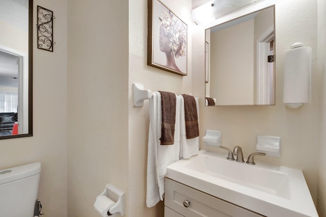 bathroom featuring toilet and vanity