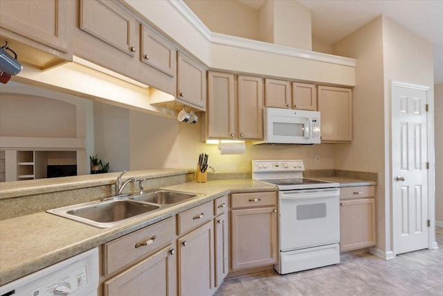 kitchen featuring white appliances, light brown cabinetry, and sink