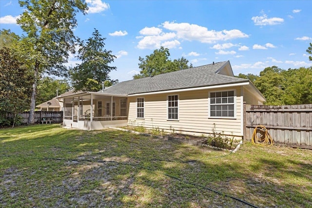 back of house with a sunroom and a yard