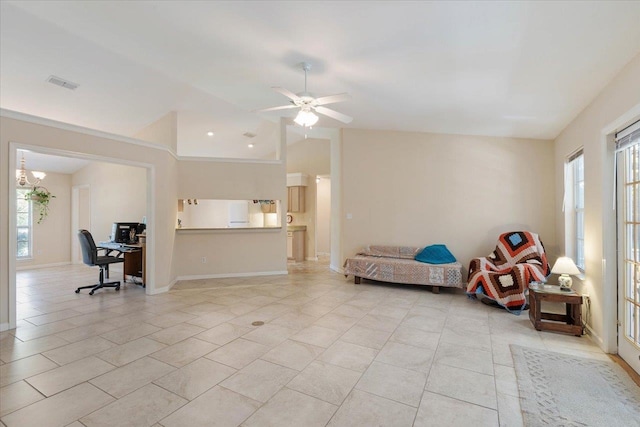 interior space with ceiling fan with notable chandelier, a healthy amount of sunlight, and vaulted ceiling