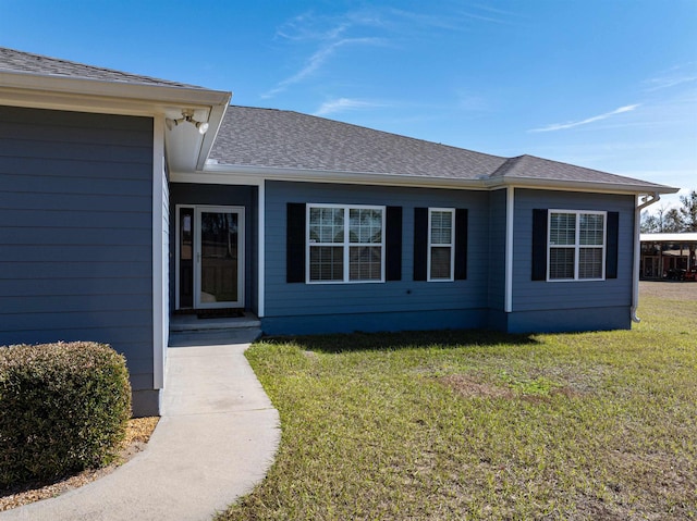 view of exterior entry with a lawn