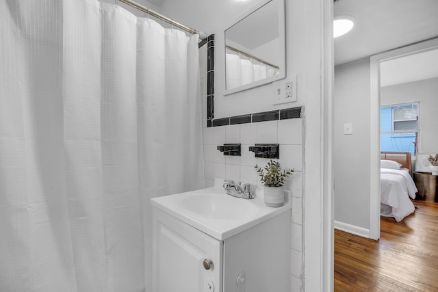 bathroom featuring vanity, hardwood / wood-style floors, and tile walls