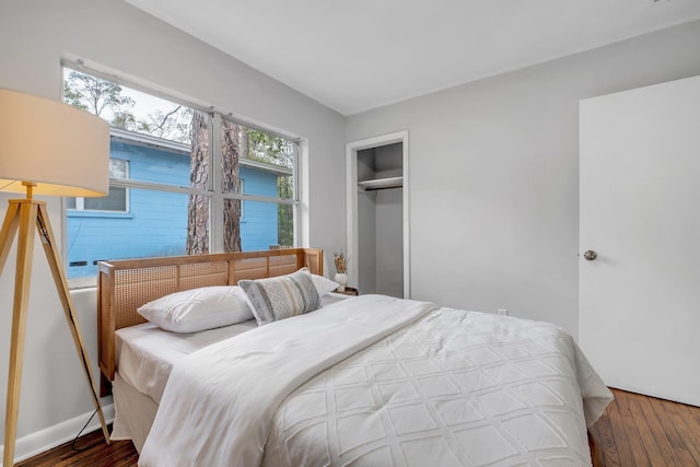 bedroom with dark hardwood / wood-style floors and a closet