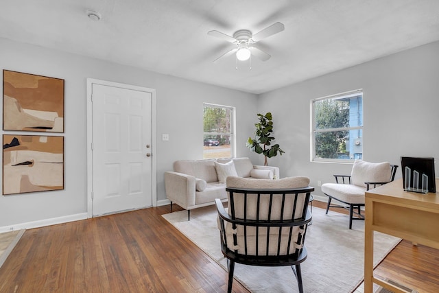 living room featuring dark hardwood / wood-style flooring, ceiling fan, and a healthy amount of sunlight