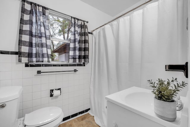 bathroom featuring toilet and tile walls