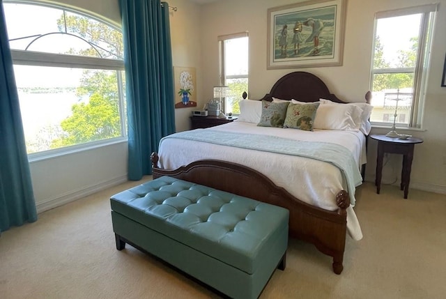 carpeted bedroom with baseboards and multiple windows