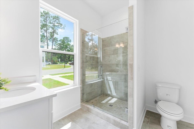 full bathroom featuring baseboards, a shower stall, toilet, tile patterned floors, and vanity
