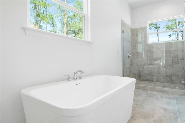 full bath with a shower stall and a freestanding tub
