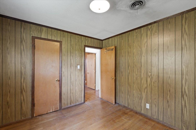 203 Forest Cir, Perry, FL 32347 - unfurnished bedroom featuring wood finished floors, wooden walls, and ornamental molding
