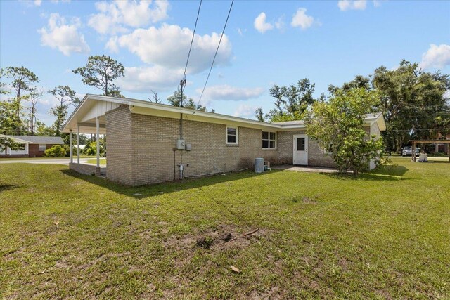 203 Forest Cir, Perry, FL 32347 - back of property featuring brick siding and a lawn