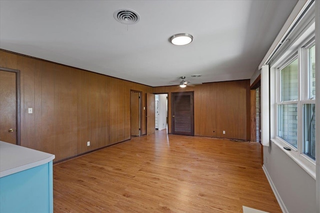 203 Forest Cir, Perry, FL 32347 - unfurnished room with light wood-type flooring, a ceiling fan, and wood walls