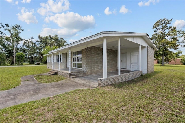 203 Forest Cir, Perry, FL 32347 - view of front facade with brick siding, a carport, and a front yard