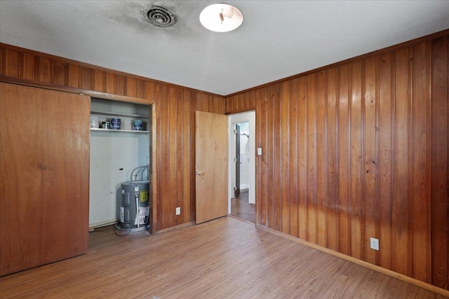 203 Forest Cir, Perry, FL 32347 - unfurnished bedroom with wood finished floors, wooden walls, and a textured ceiling