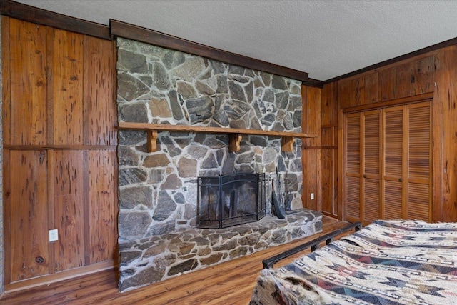 203 Forest Cir, Perry, FL 32347 - unfurnished bedroom featuring wood walls, a textured ceiling, wood finished floors, a closet, and ornamental molding