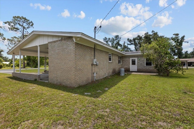 203 Forest Cir, Perry, FL 32347 - view of property exterior featuring brick siding, a lawn, and an attached carport