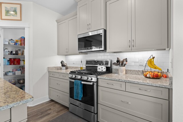 2848 Crestline Rd, Tallahassee, FL 32308 - kitchen with appliances with stainless steel finishes, dark wood finished floors, tasteful backsplash, and gray cabinetry