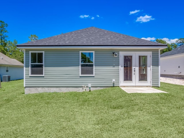 rear view of property featuring central AC unit and a yard