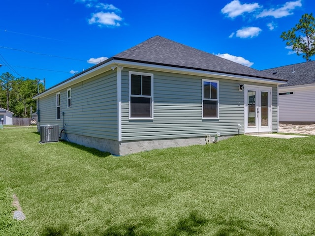 back of property featuring central AC unit, a lawn, and french doors