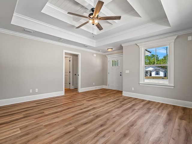 unfurnished room with a tray ceiling, crown molding, and light hardwood / wood-style flooring